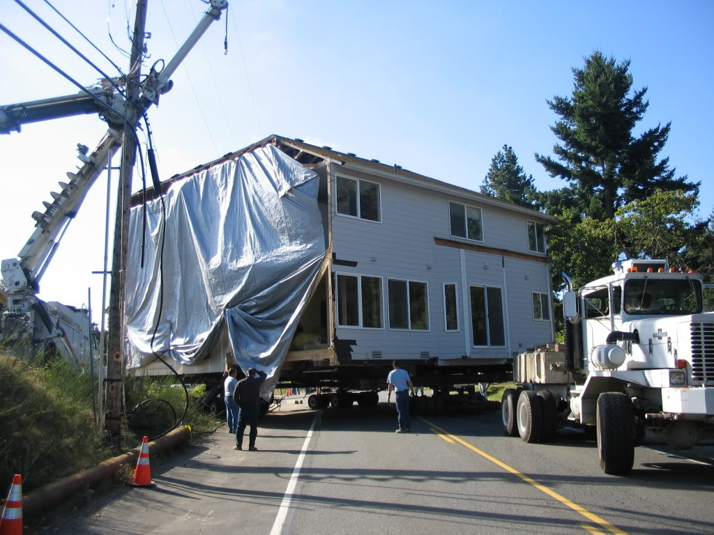 855 Graham Ave NE, Renton, WA - house in transit, wrapped and braced on flatbed truck